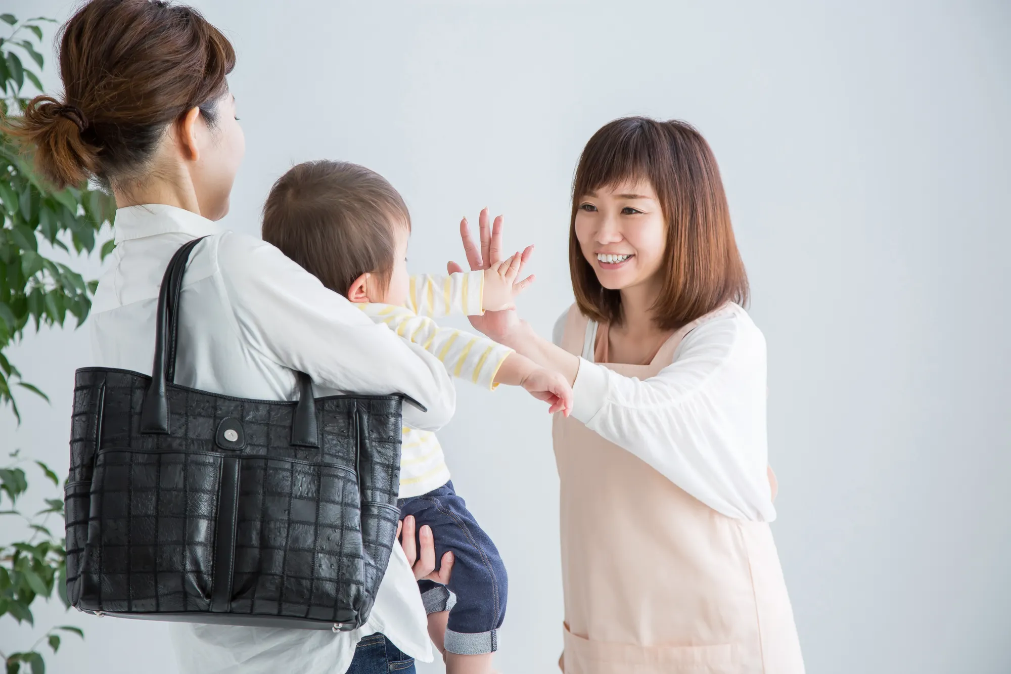 保育士に子どもを預ける母親