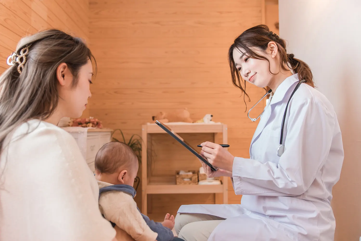 赤ちゃんを診察する医師と母親